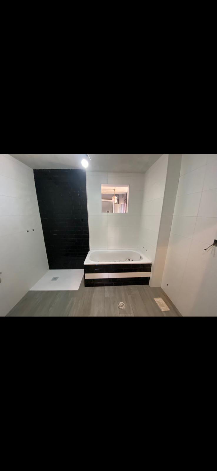 Reforma de baño con bañera y diseño blanco negro