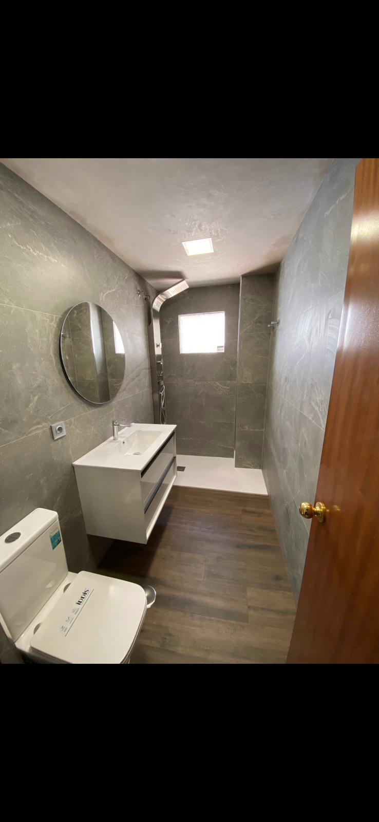 Reforma de baño con mármol y grifería dorada en Sevilla