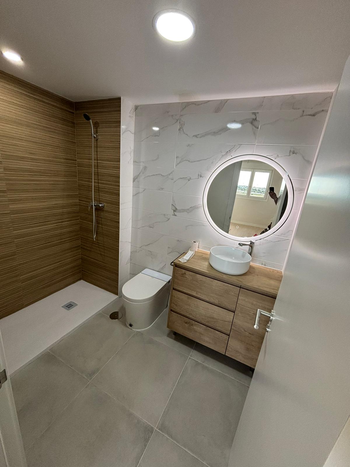 Reforma de baño moderno en Sevilla con espejo LED